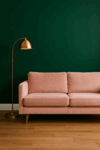 Emerald feature wall behind pastel-blush velvet sofa and gold floor lamp.